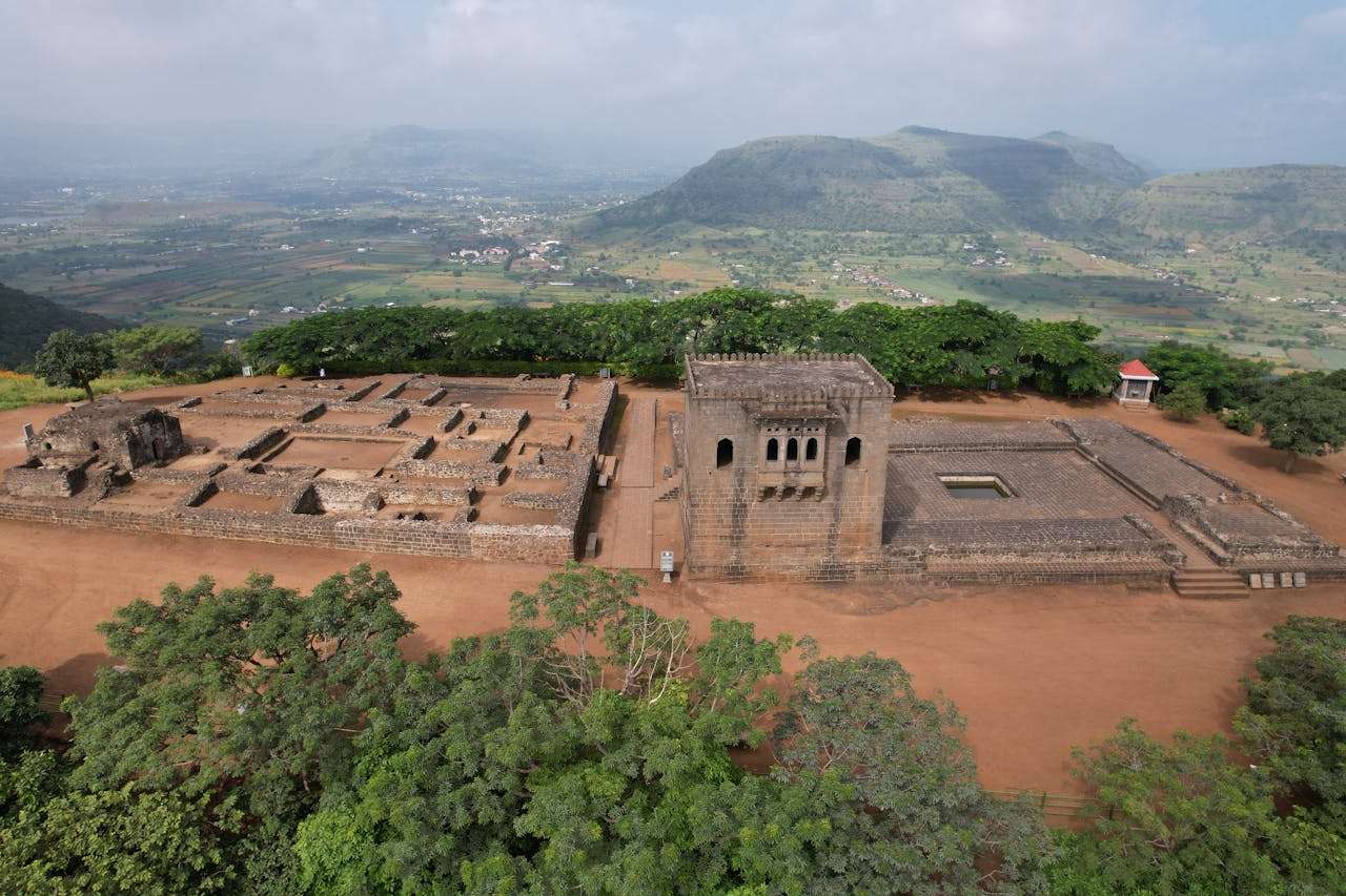 Drone capture of Raigad Fort ruins in Maharashtra set against lush hills.